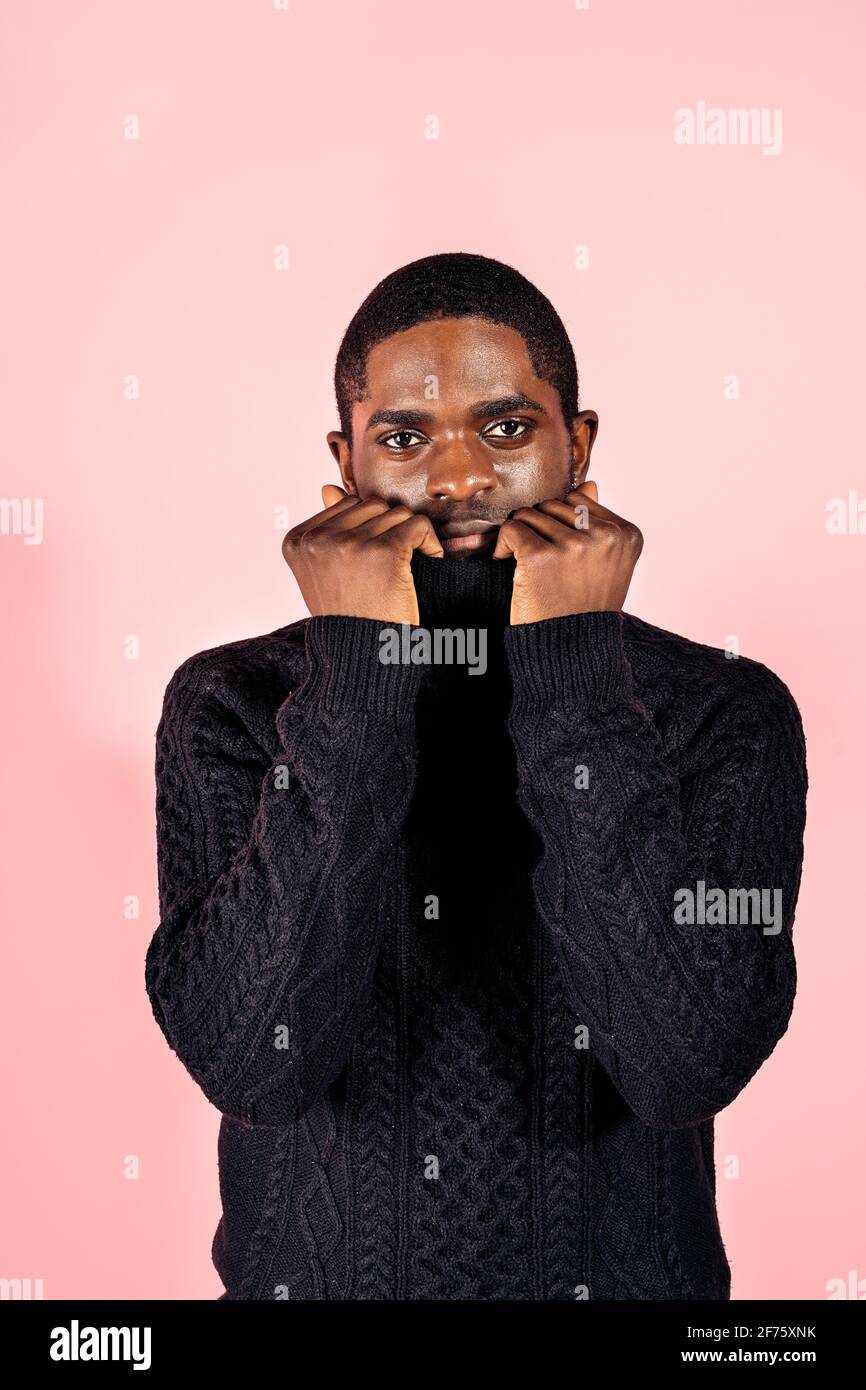 Stock photo of serious black man covering his face with his jumper and ...