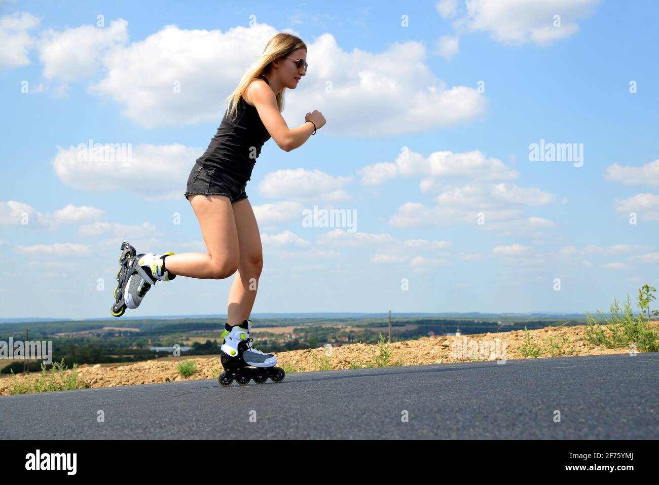 Teenage girl on roller skates at summer. Inline skating on the road