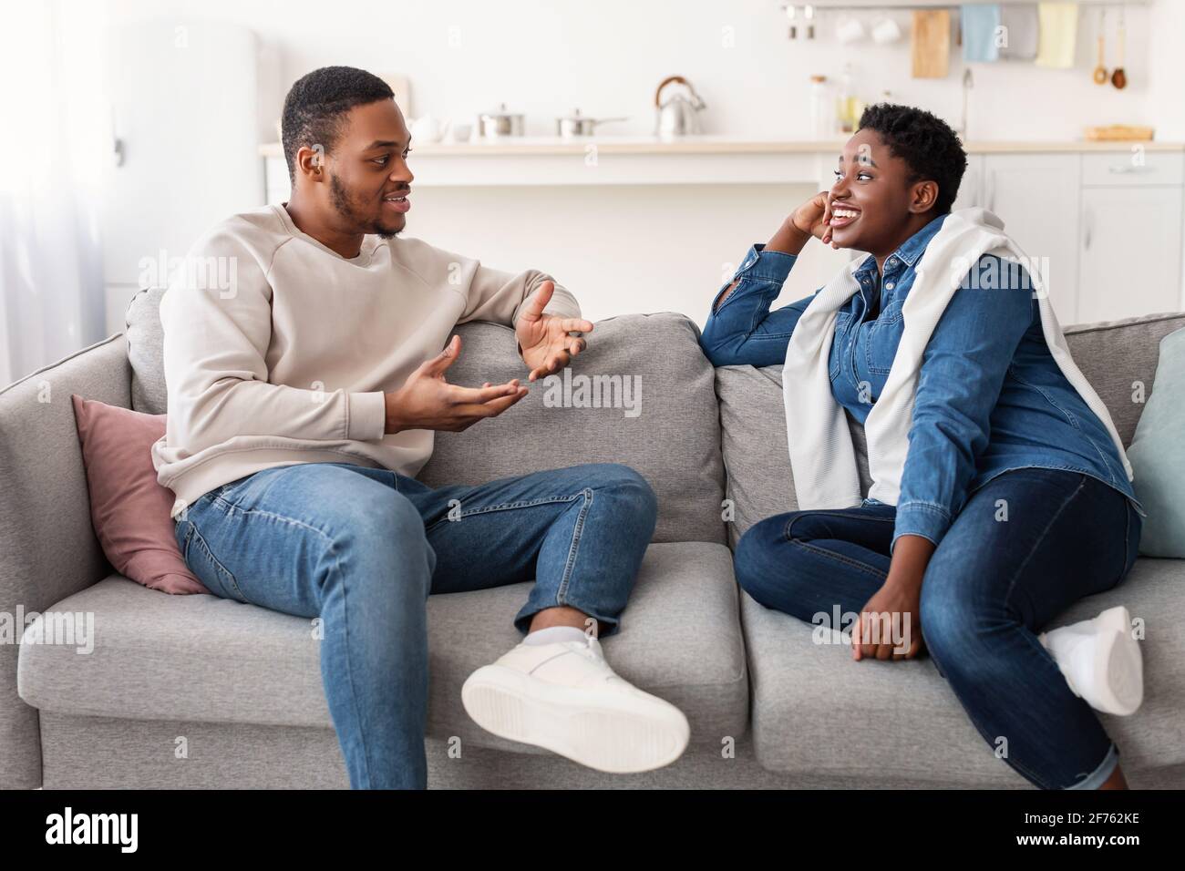 Black couple talking and spending time together sitting on couch Stock