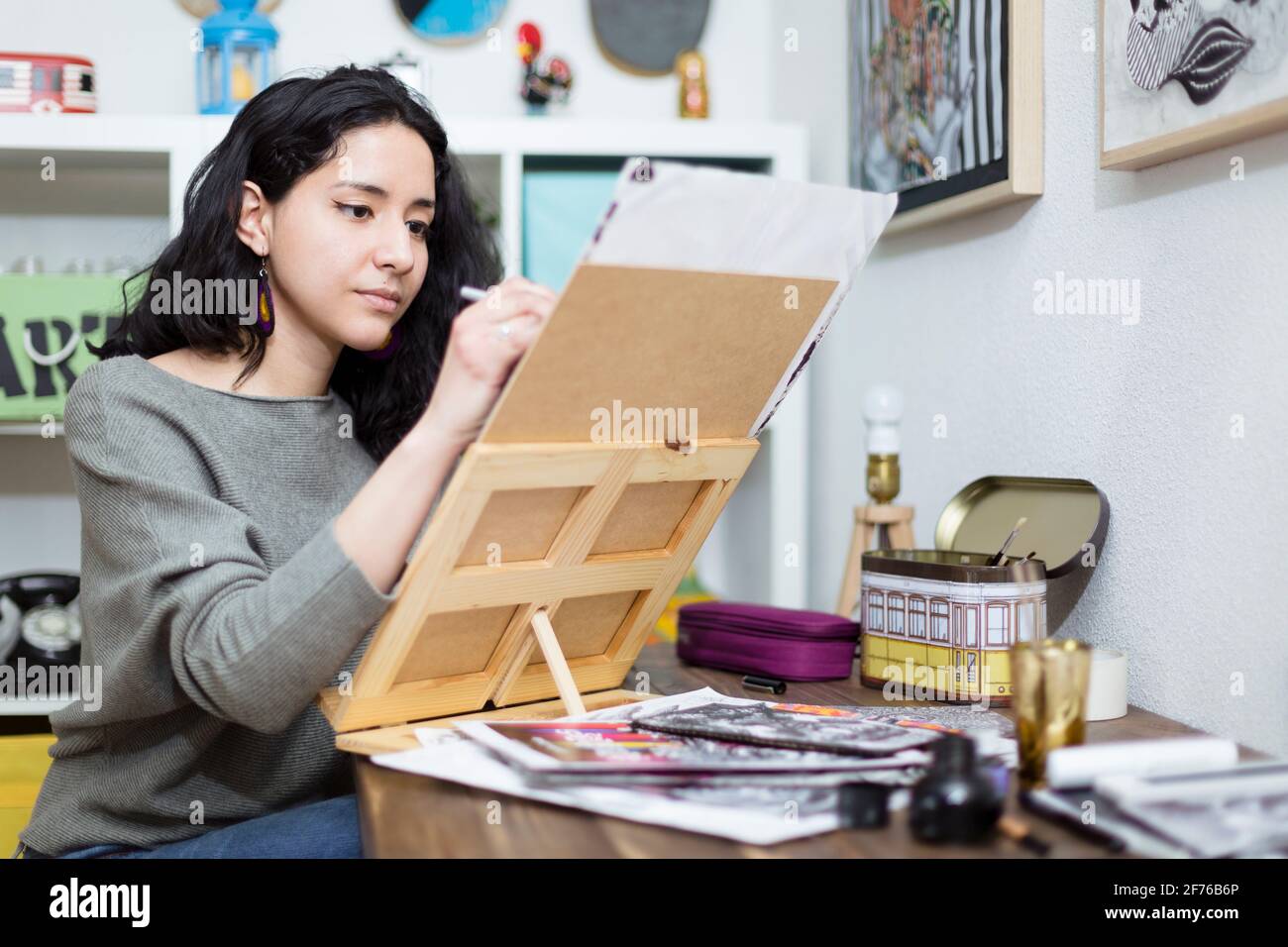 Young woman artist concentrating on the project she is working on. Home entertainment concept. Stock Photo