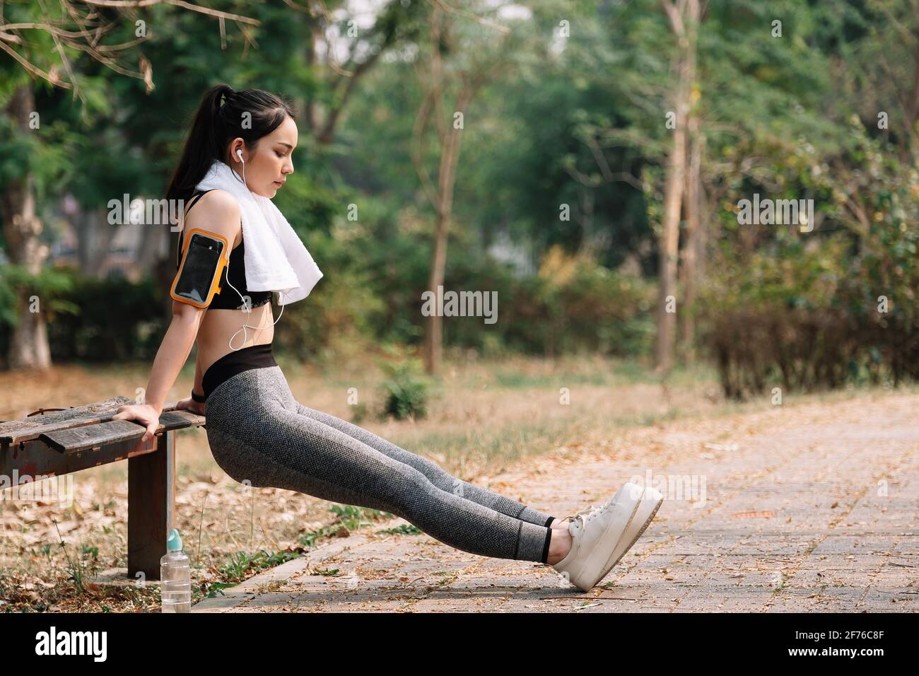 fitness, sport, exercising and lifestyle concept - woman stretching leg on stands. Stock Photo