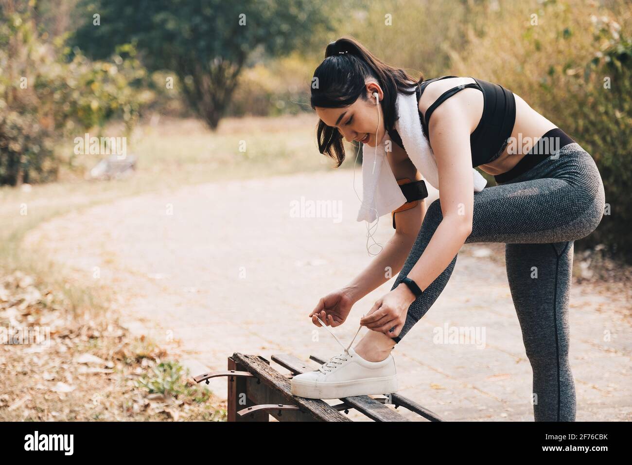 Portrait of beautiful asian young woman runner tying her shoelaces. healthy and fitness concept Stock Photo