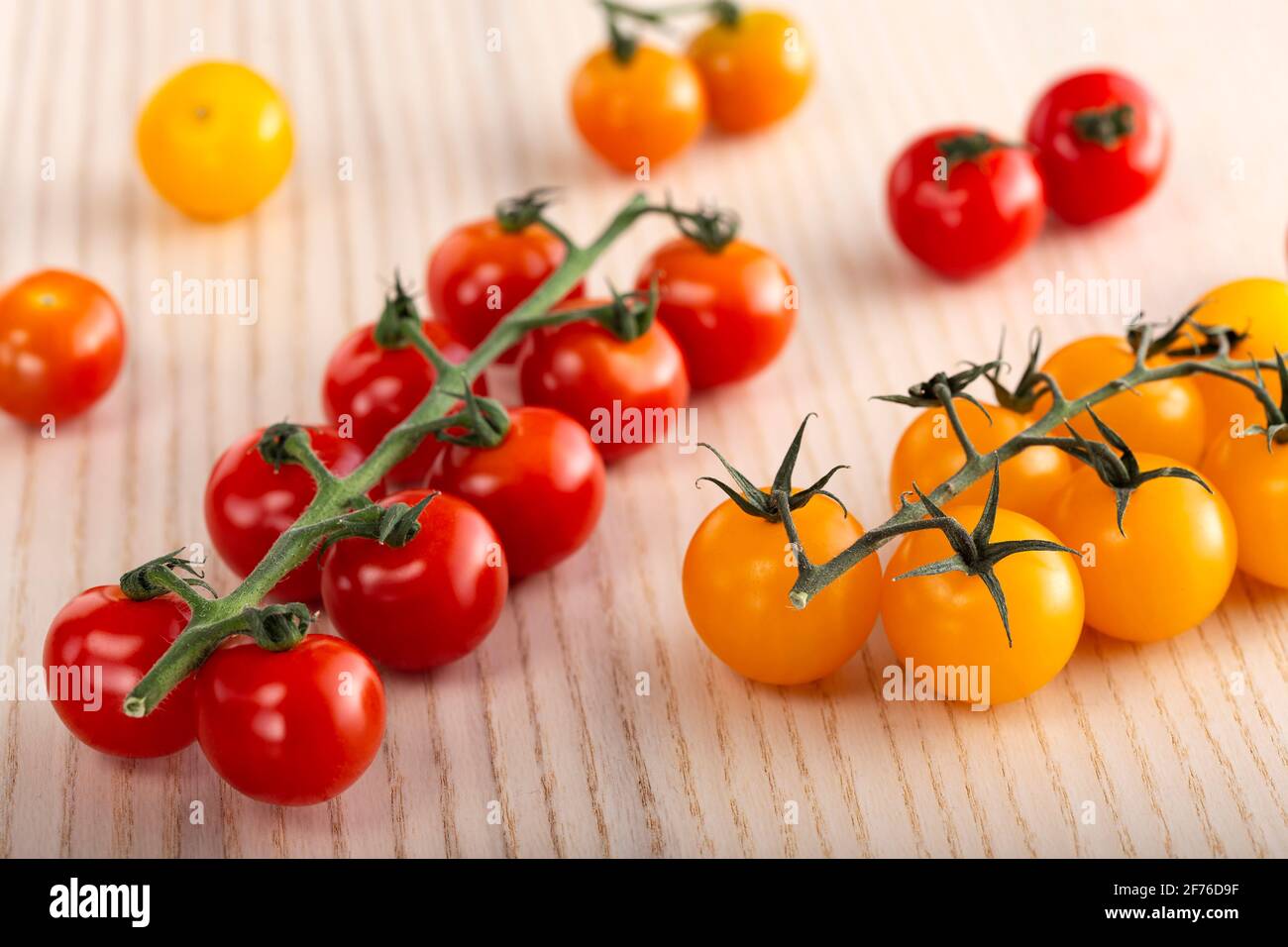 Red and yellow cherry  tomatoes on a wooden table Stock Photo