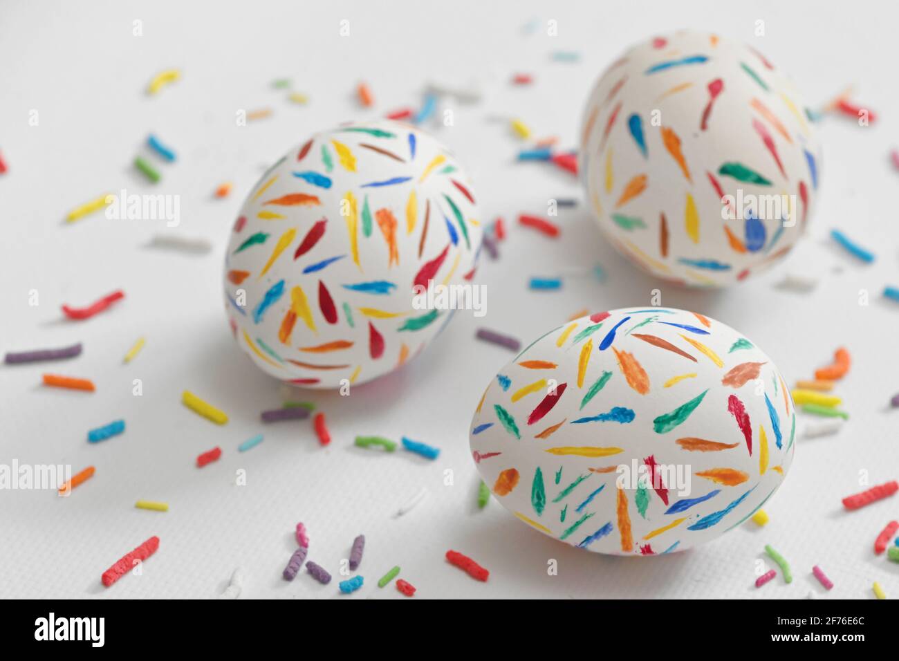 Painted Sprinkle Easter Eggs on white table Stock Photo