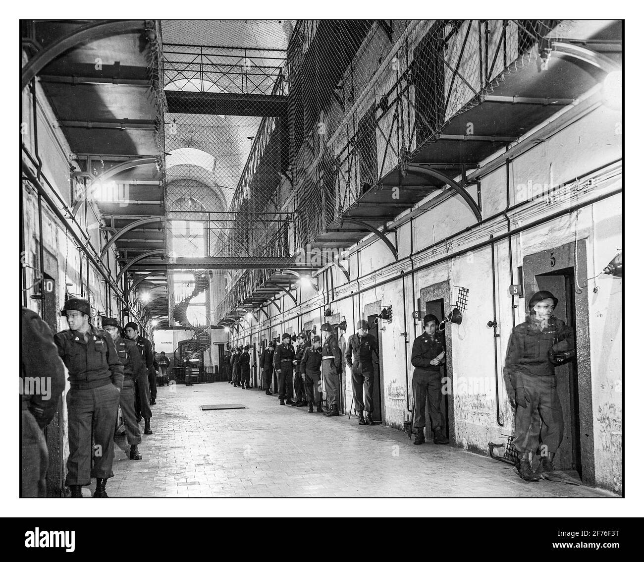 NUREMBERG NAZI PRISON CELLS 1945 Main section of prisoners' call block in the Nuernberg jail. 'Cells occupied by Goering and Hess are at extreme right. Each defendant is watched by an individual guard who is constantly posted at his door. 11/24/45. Datebetween circa 1945 and circa 1946 Stock Photo