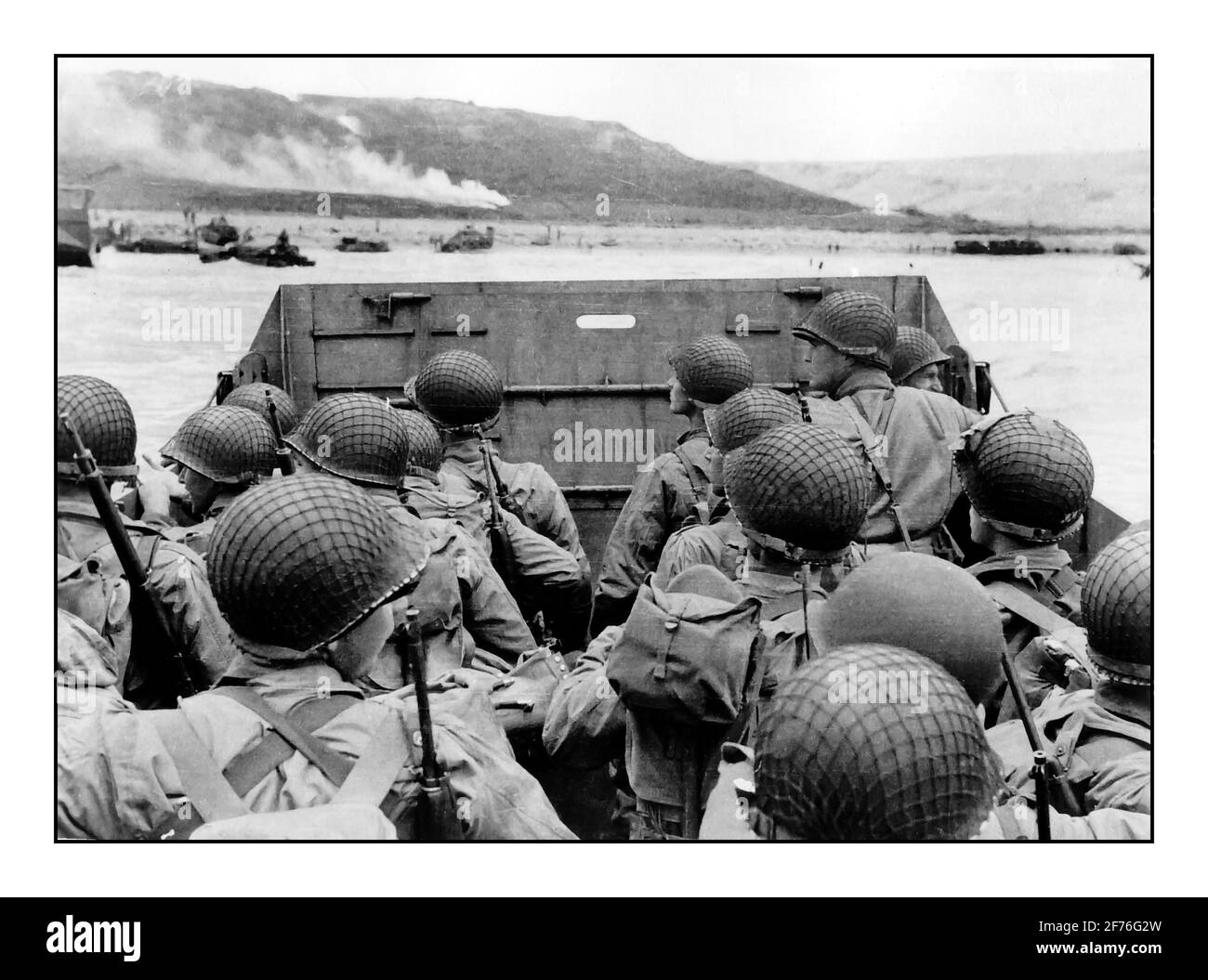 D-Day Omaha invasion beach landing craft under dull skies with American troops in landing craft visually guided by smoke flares approaching Omaha Beach Normandy France 6th June 1944 Stock Photo