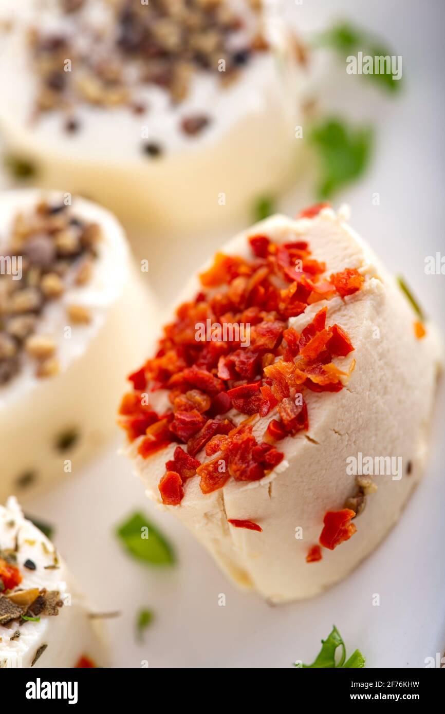 Small cheese appetizers with herbs and dried vegetables - close up view Stock Photo