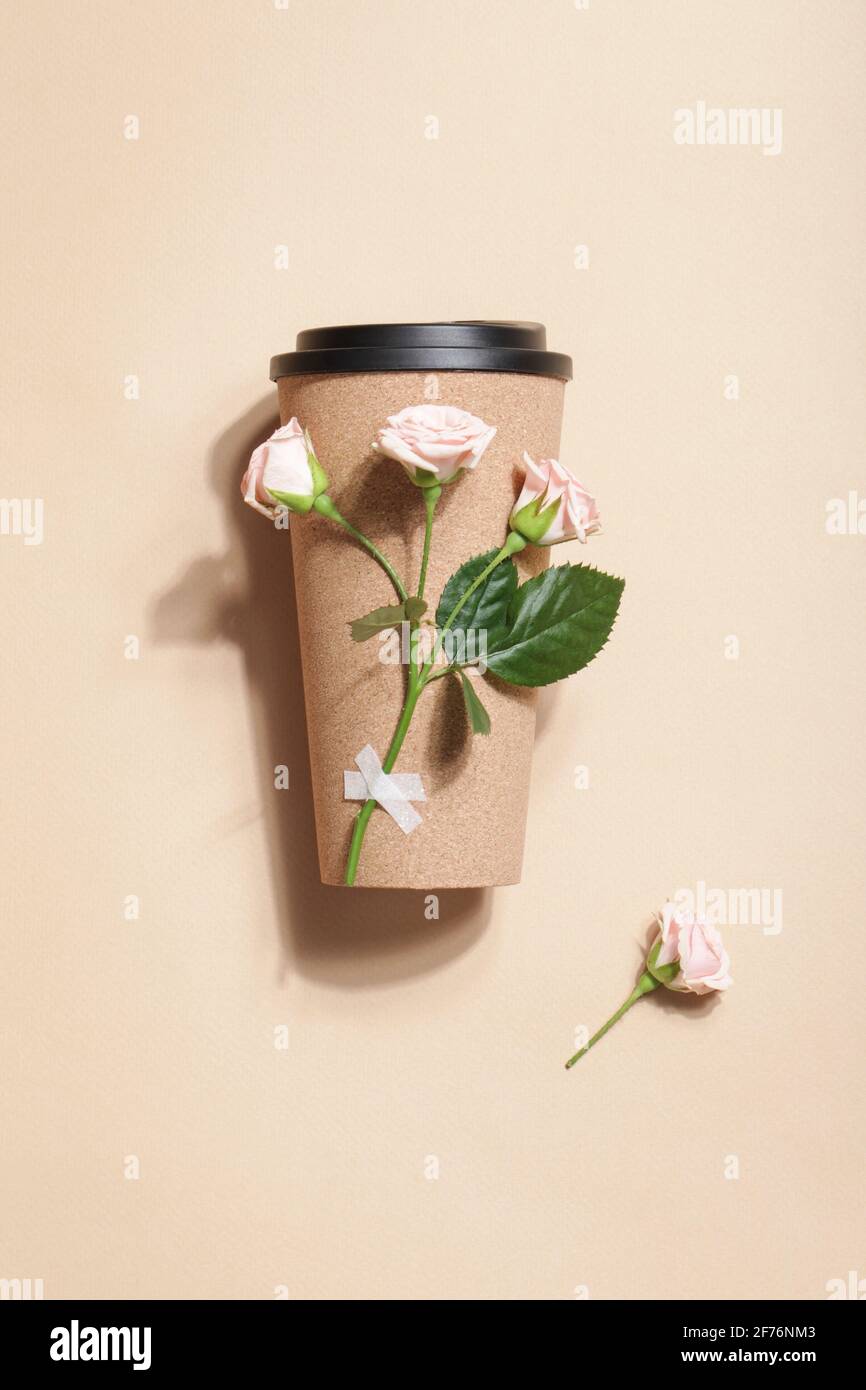 reusable eco coffee or tea cup with branch of roses on beige background. Sustainable lifestyle. Eco friendly and Zero waste concept.Flat lay Stock Photo