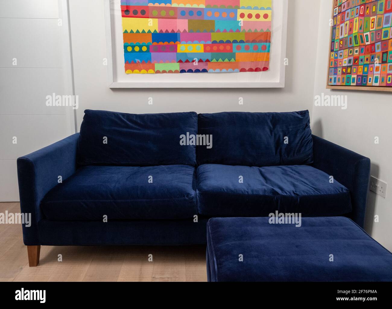 Comfortable blue velvet sofa with matching blue velvet footstool and
