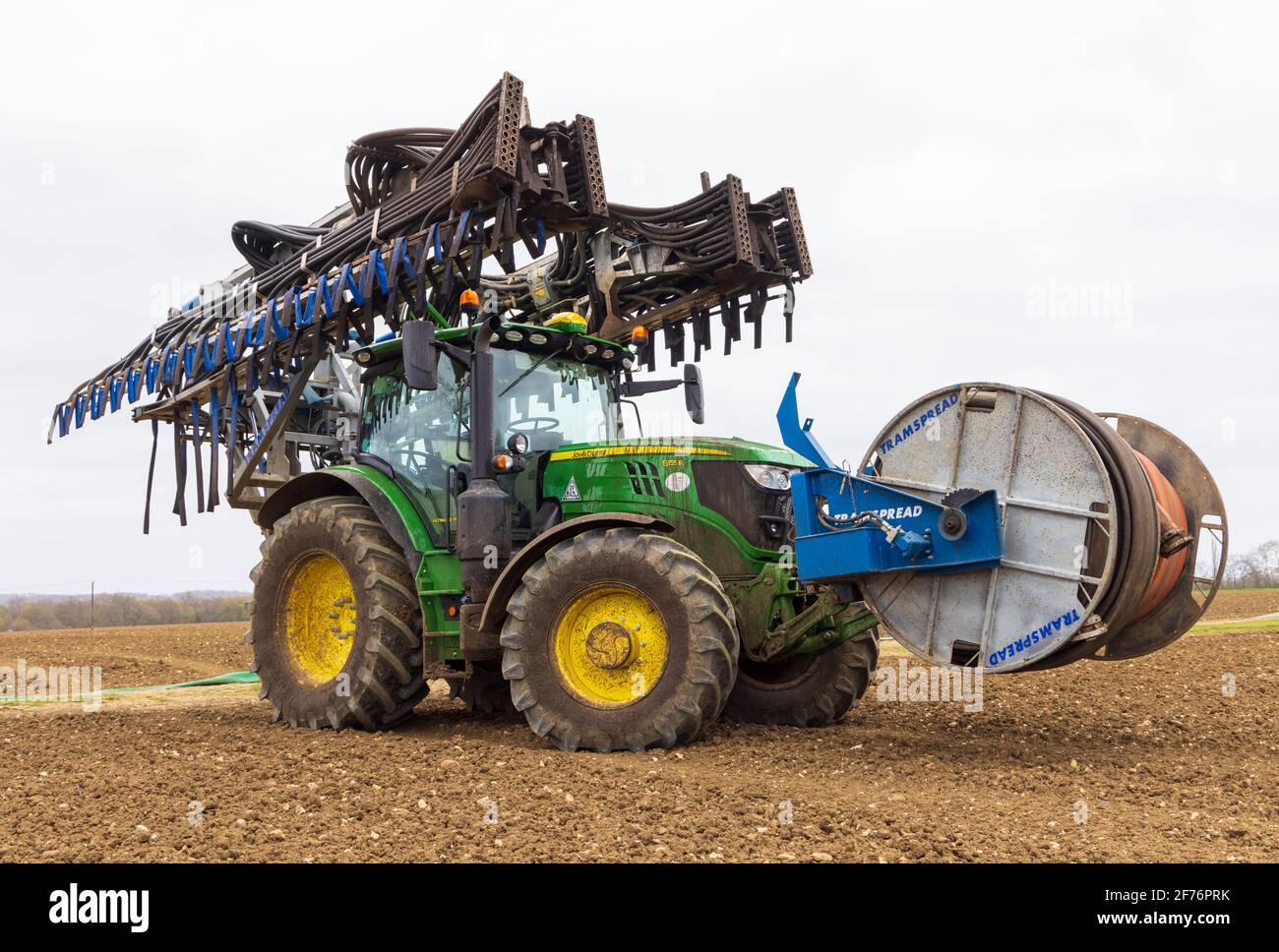 https://c8.alamy.com/comp/2F76PRK/tractor-with-a-folded-tramspread-slurry-spreader-dribble-bar-and-mounted-hose-reeler-used-to-apply-slurry-to-fields-hertfordshire-uk-2F76PRK.jpg