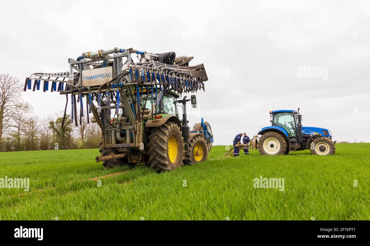 Men preparing tractor with a folded Tramspread slurry spreader Dribble Bar. Hertfordshire, UK Stock Photo