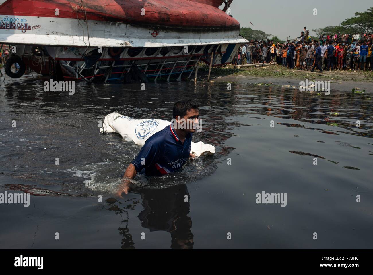 (EDITORS NOTE: Image depicts death)A member of the rescue team seen pulling a dead body in bag just after pulling out the capsized boat from the Shitalakshya River. A Bangladeshi ferry capsized after colliding with a cargo vessel on Sunday in Shitalakkhya river south of the capital Dhaka, leaving at least 26 people dead and a few still missing. Stock Photo