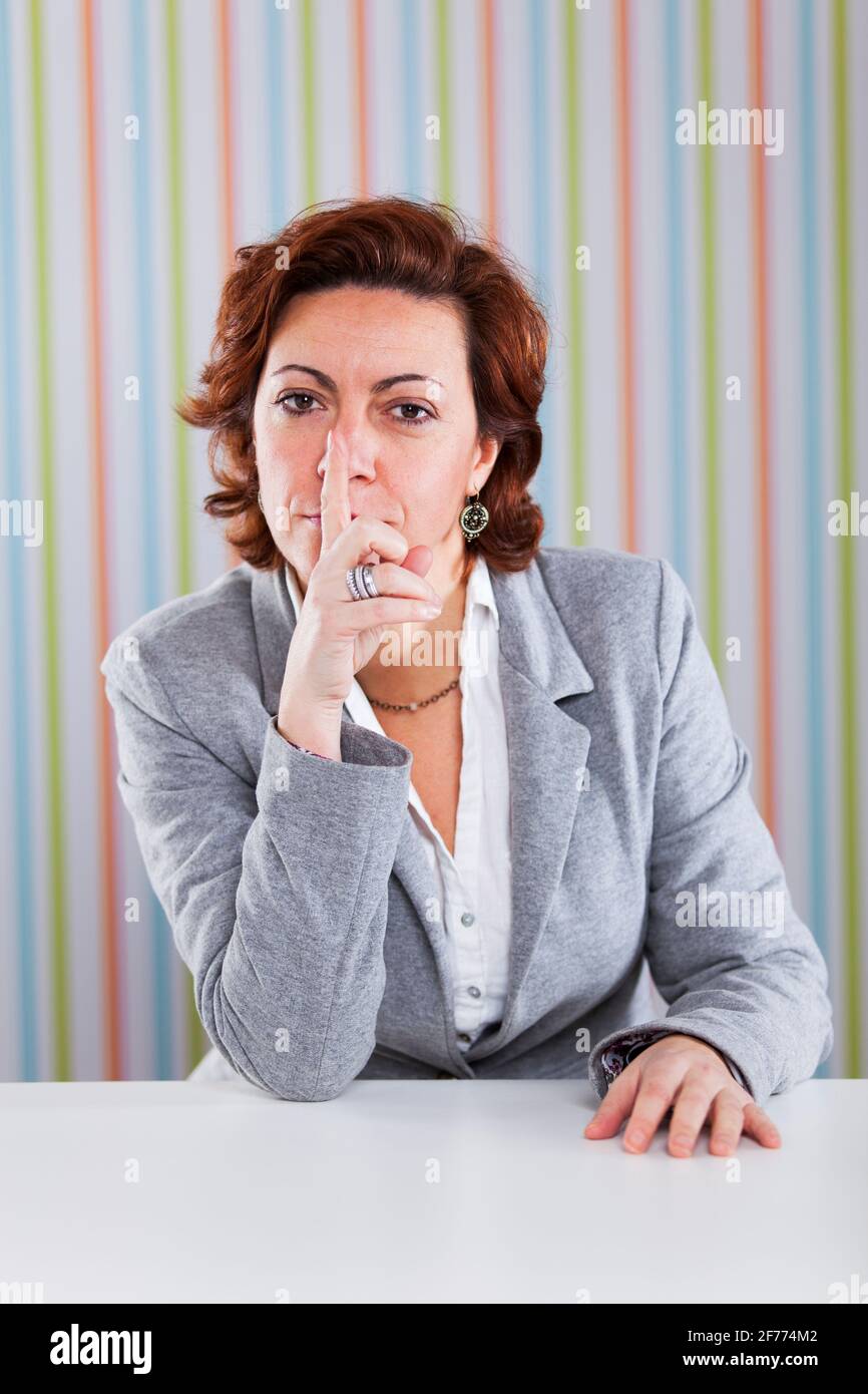 Businesswoman with a silence gesture Stock Photo