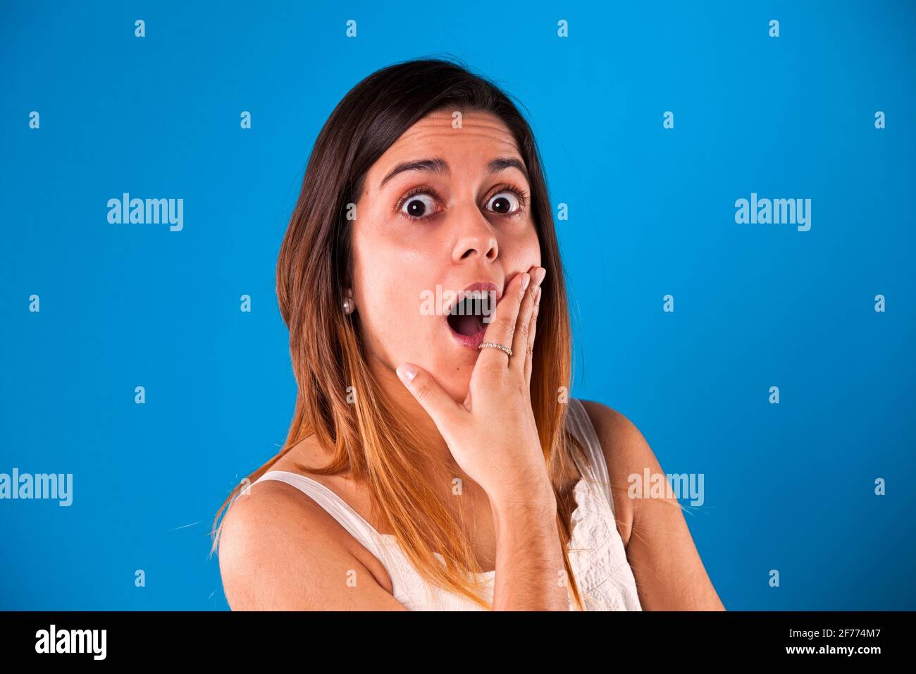 Surprised young woman with a blue background Stock Photo