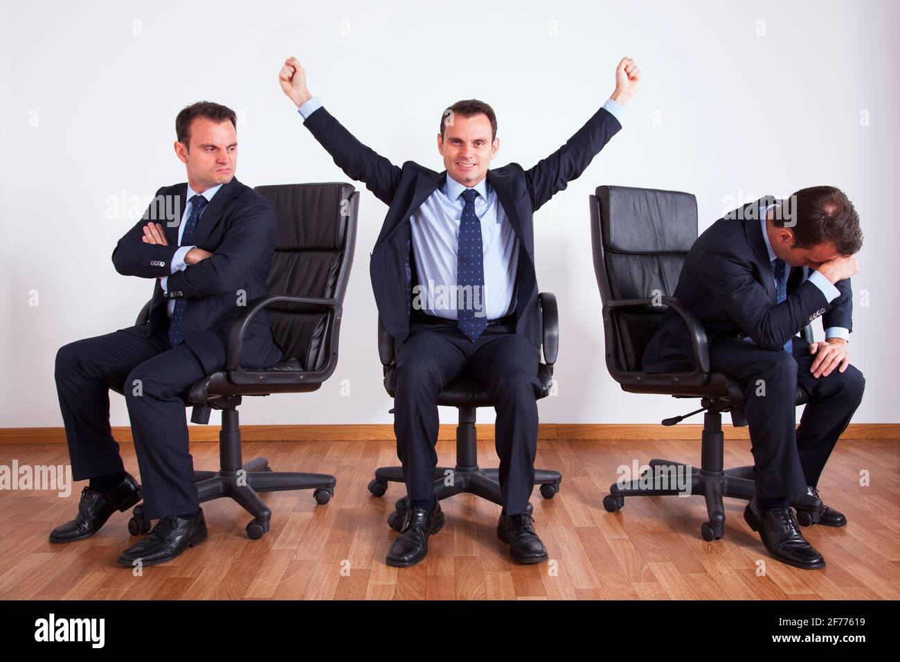 One successful businessman between two jealous businessman Stock Photo