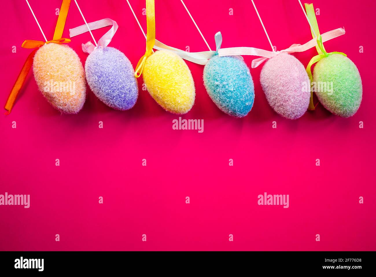 Fluffy colorful plastic eggs isolated on red background. Easter concept. Copy space Stock Photo