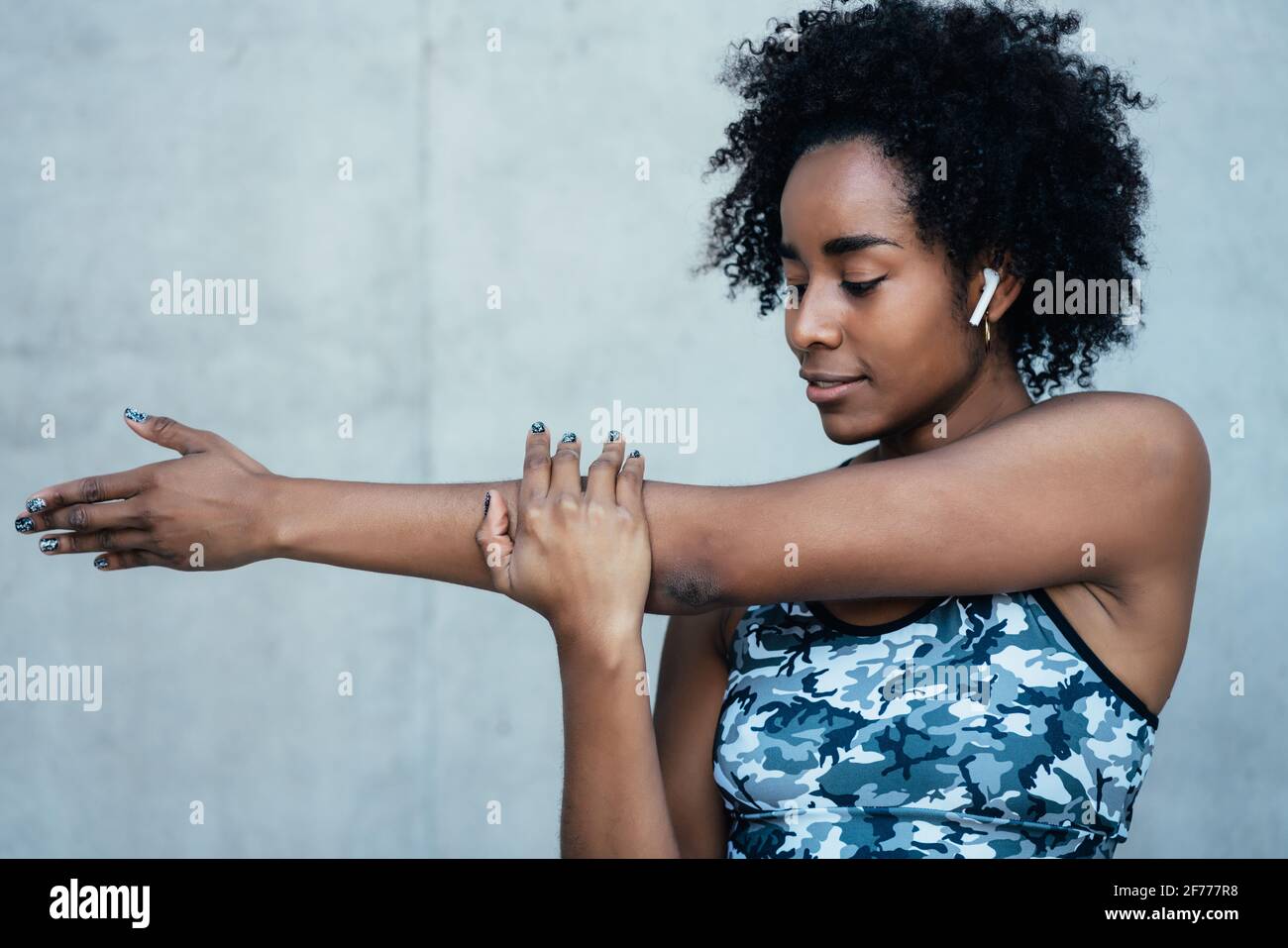 Afro athletic woman stretching arms before exercise. Stock Photo