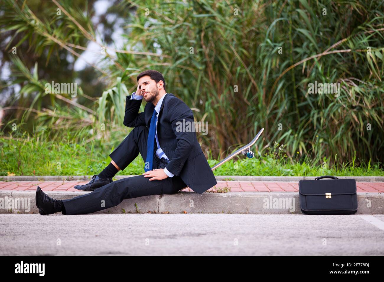 Businessman resting with his skateboard Stock Photo