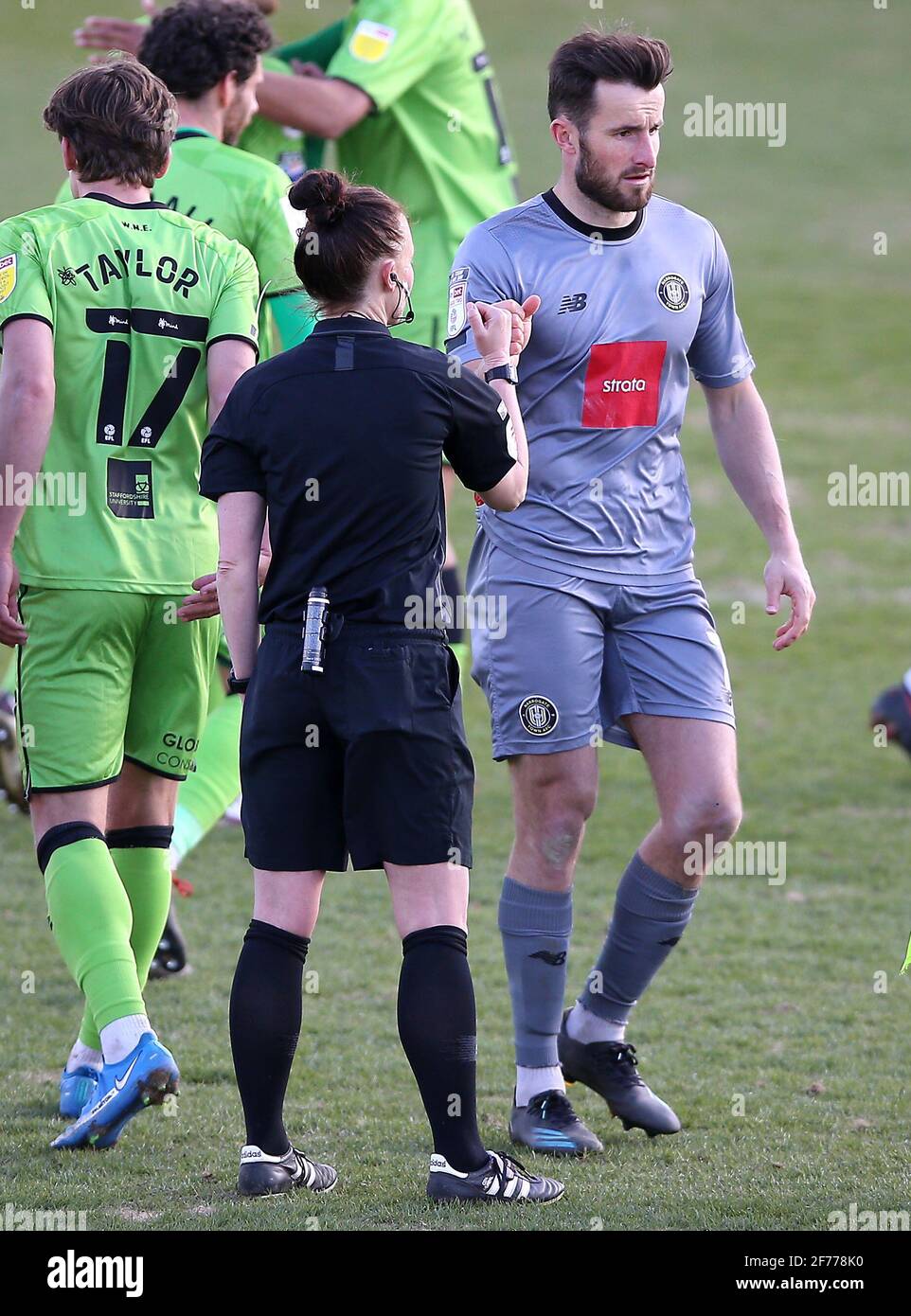 Referee Rebecca Welch (left) and Harrogate Town goalkeeper James Belshaw shake hands after the final whistle during the Sky Bet League Two match at the EnviroVent Stadium, Harrogate. Picture date: Monday April 5, 2021. Stock Photo