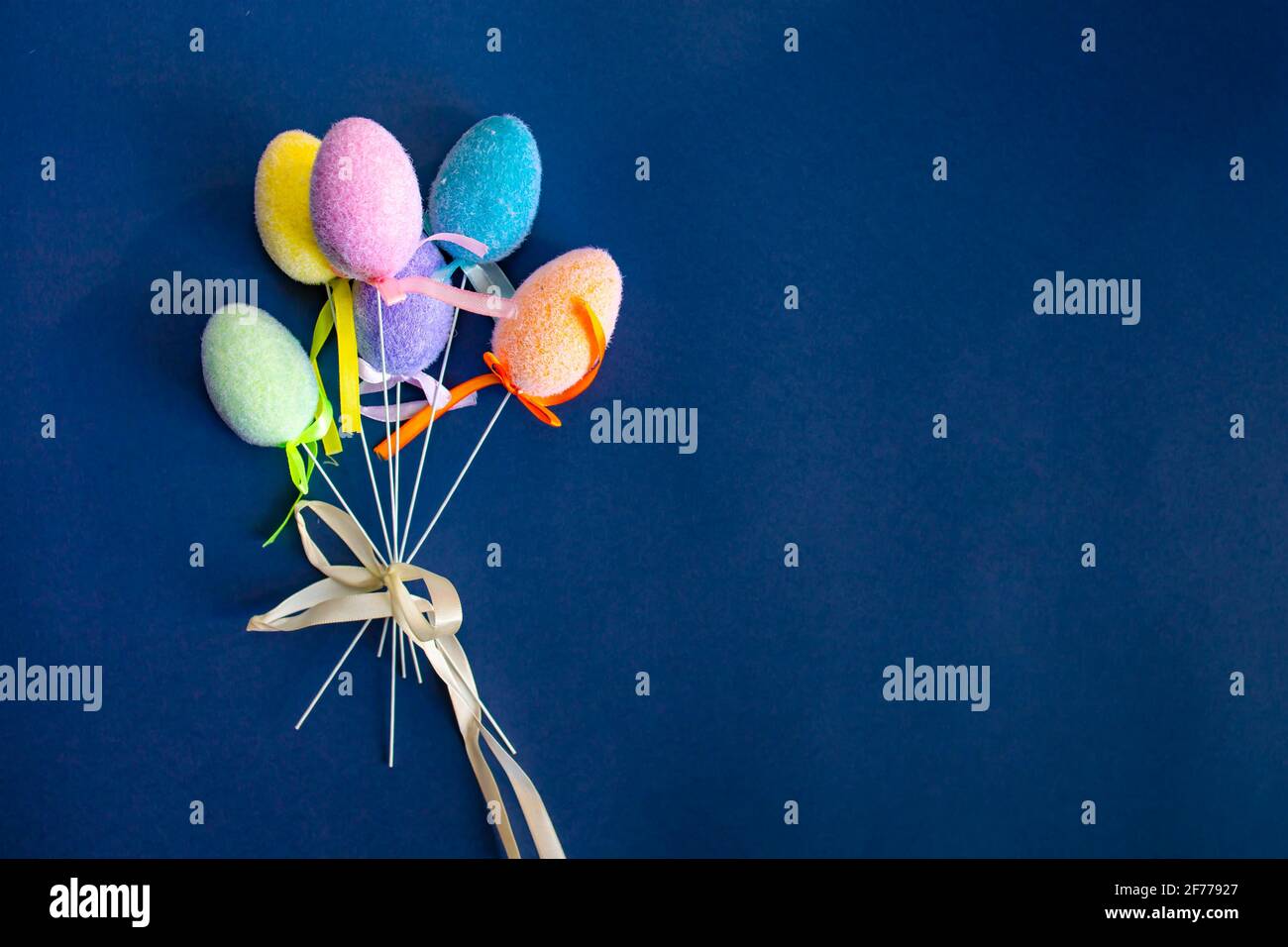 Fluffy colorful plastic eggs isolated on dark blue background. Easter concept. Copy space Stock Photo