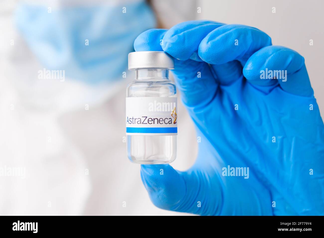 Astra Zeneca vial or bottle for injection with pharmaceuticals or drugs in scientist hands in rubber gloves. March 2021, San Francisco, USA Stock Photo