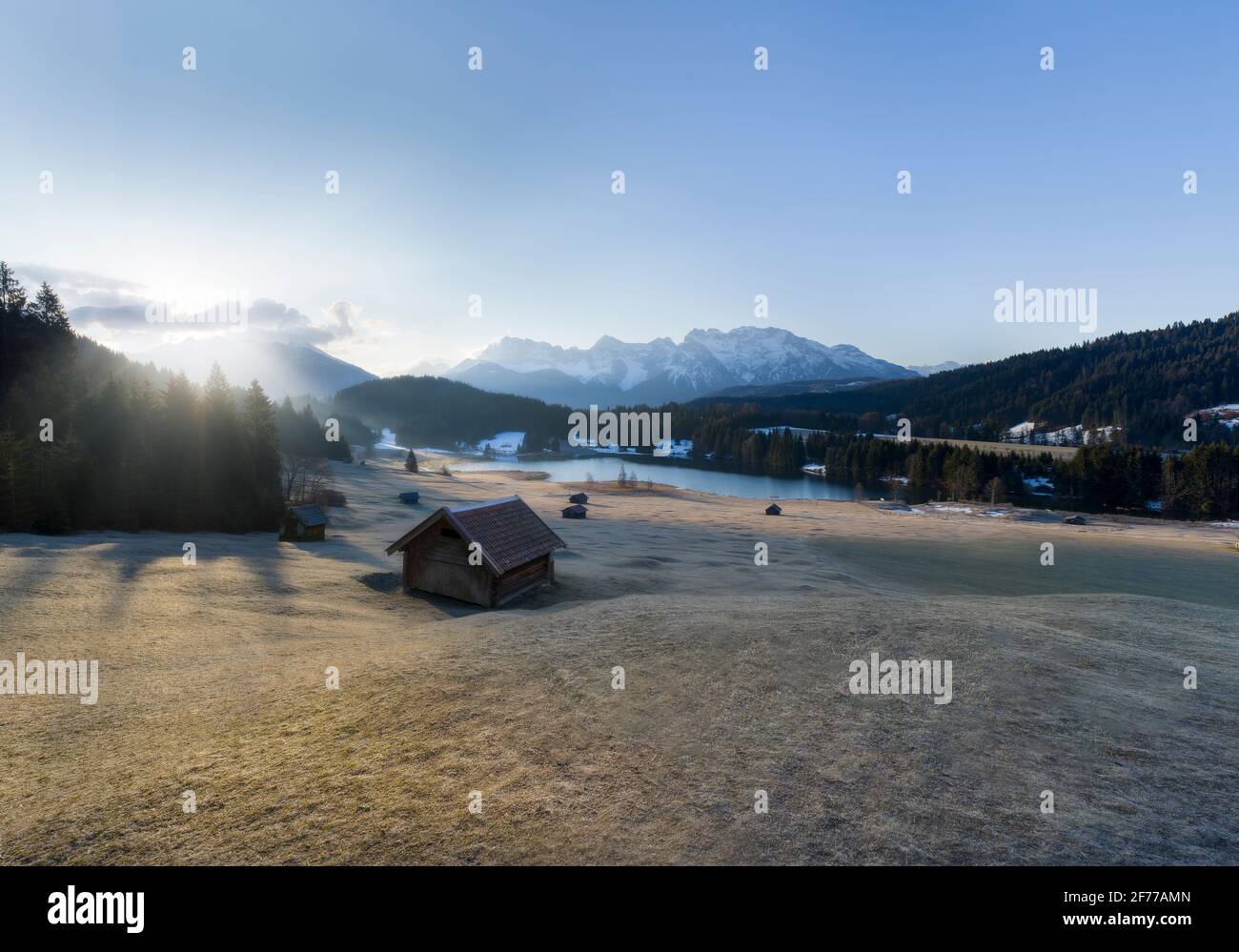 Beautiful Morning Light at Alpine Meadow with huts, lake and mountains Stock Photo