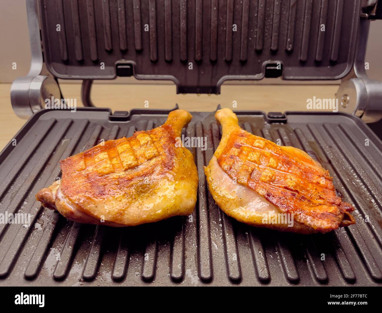 Homemade grilled duck thighs. Preparing duck meat on electric grill