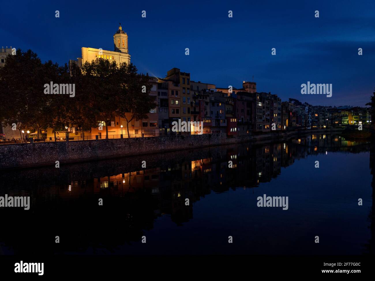 Girona historic neighborhood at the evening blue hour, with the Onyar river in the foreground and the Cathedral in the background (Catalonia, Spain) Stock Photo