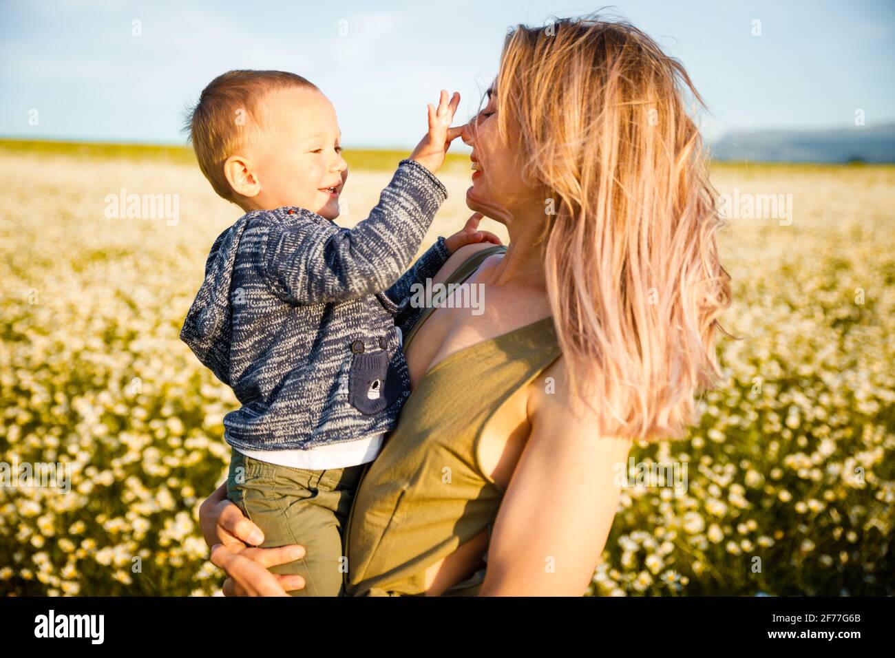 Happy childhood with mother. The child holds the hand of the parents. Stock Photo