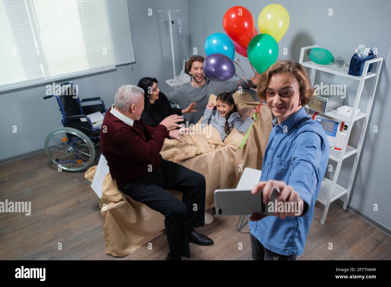A family visiting a little girl in rehab, they are taking a selfie. Stock Photo