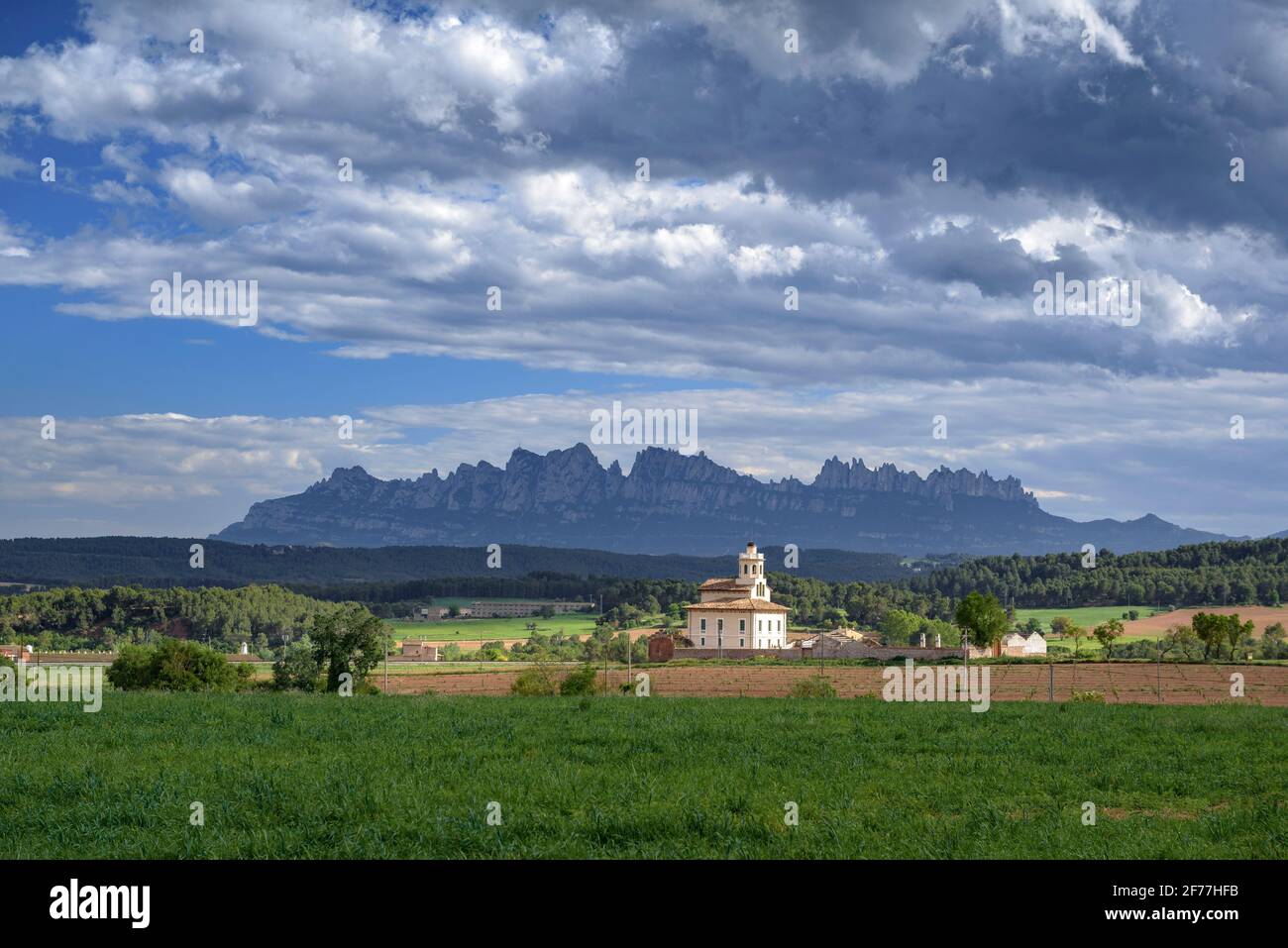 Montserrat mountain and Torre Lluvià tower, in Manresa and Pla de Bages, in a spring afternoon (Barcelona province, Catalonia, Spain) Stock Photo