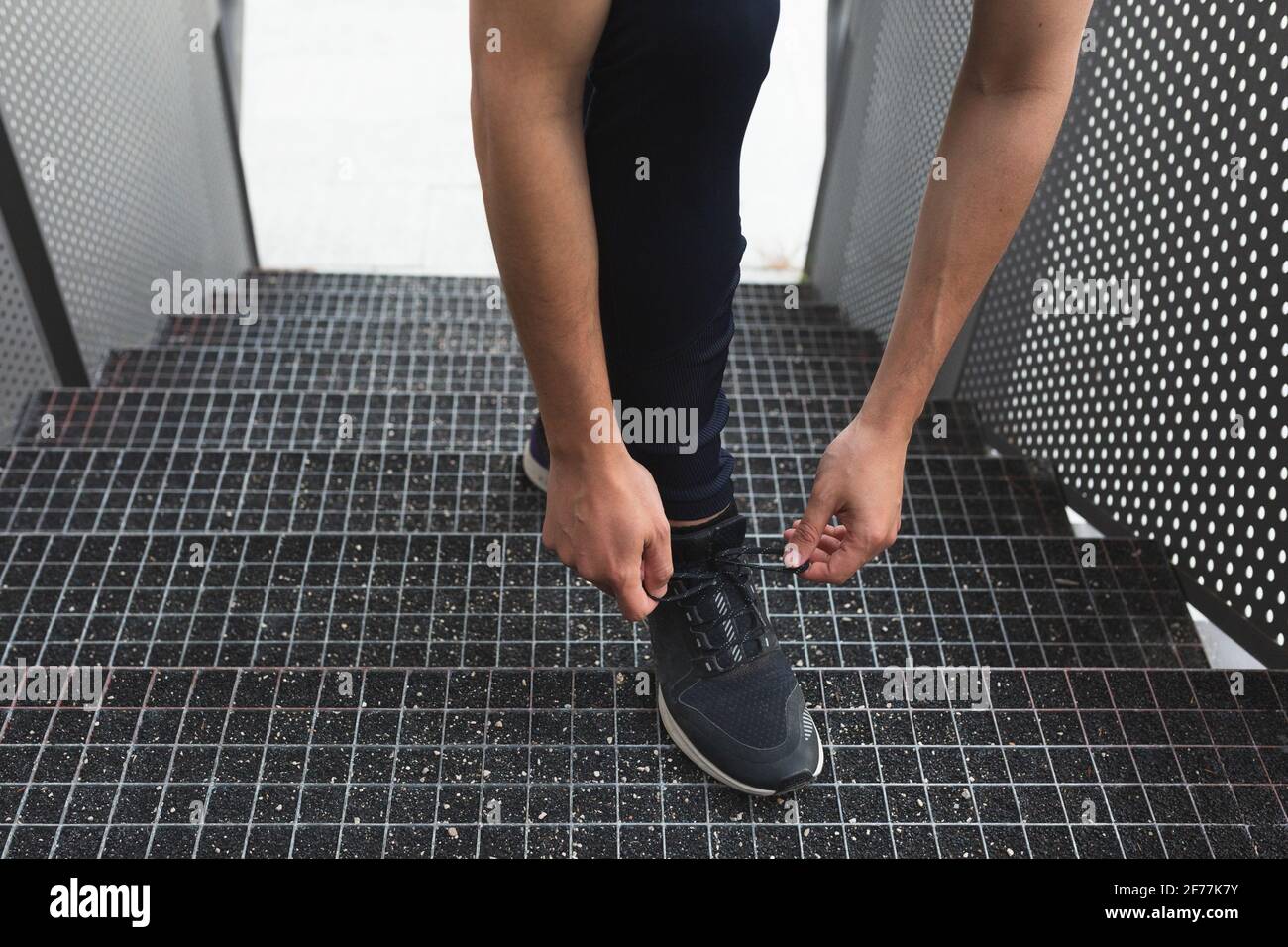 an anonymous male athlete laces up his shoes for running training Stock Photo
