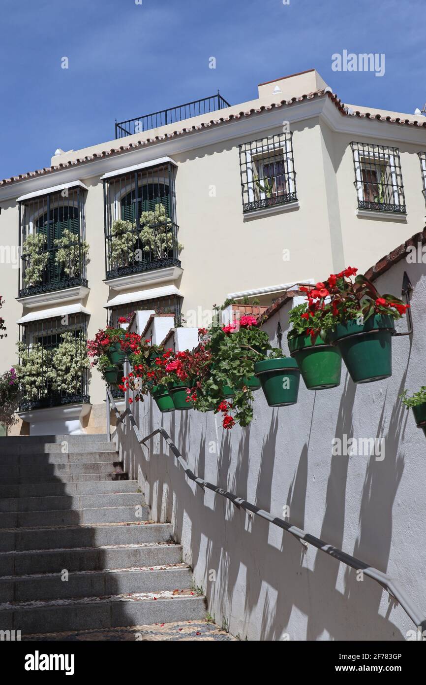 Steps half in shade with colourful flowers in pots in Estepona, Spain Stock Photo
