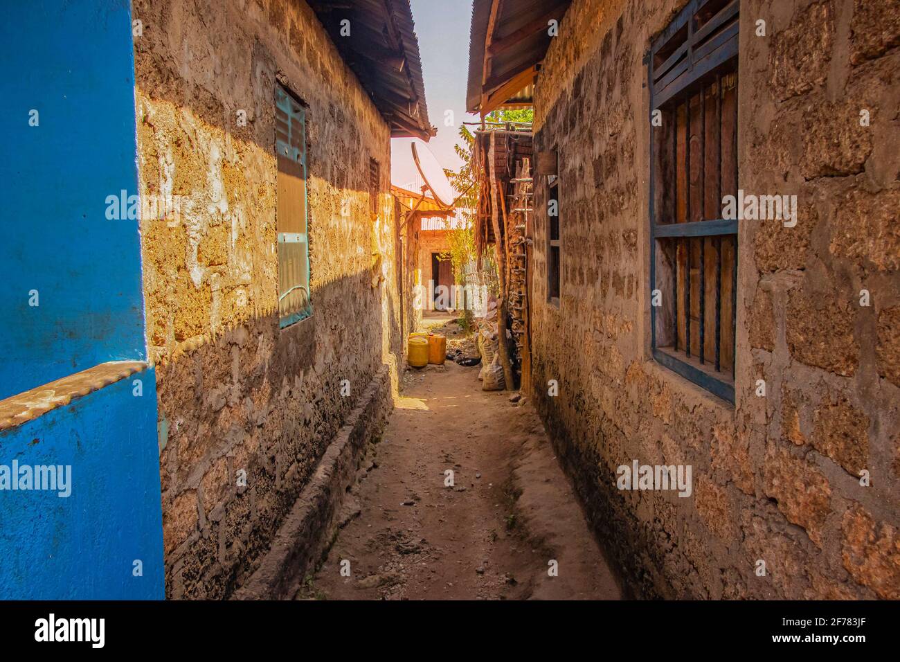 Narrow alley between typical stone houses in an African village on Wasini island. It is a small hamlet in Kenya. Stock Photo