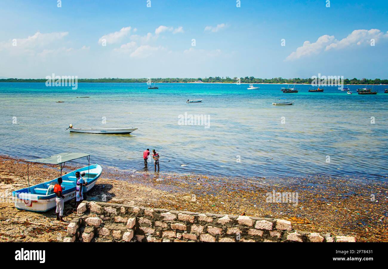 Wasini island, Kenya, AFRICA - February 26, 2020: Men and ships and small boats on the water on wild island. It is the pure blue Indian Ocean. Stock Photo