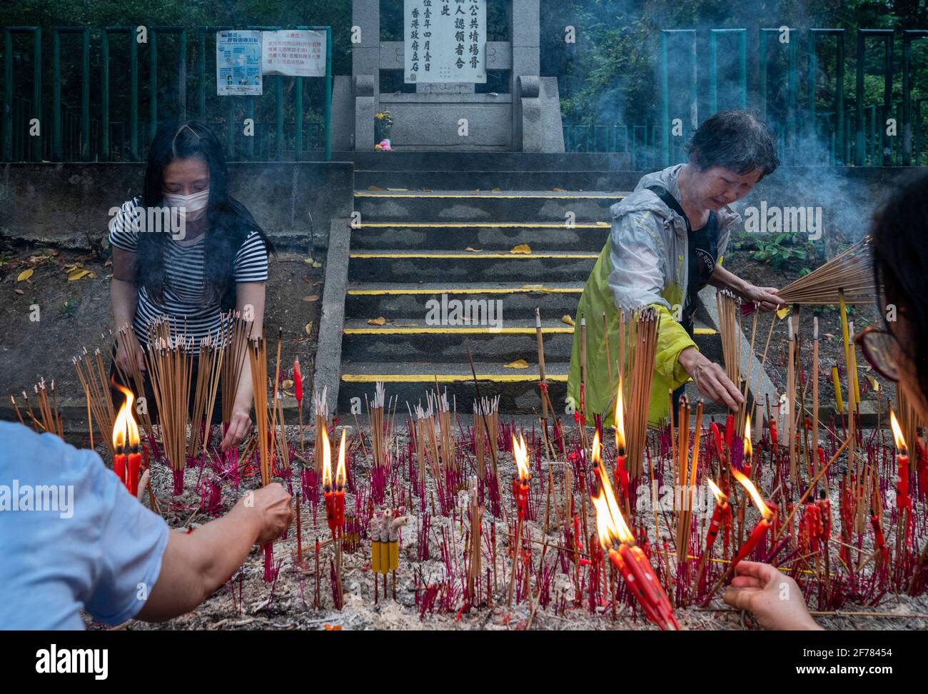People burn incense at a cemetery during the Ching Ming Festival