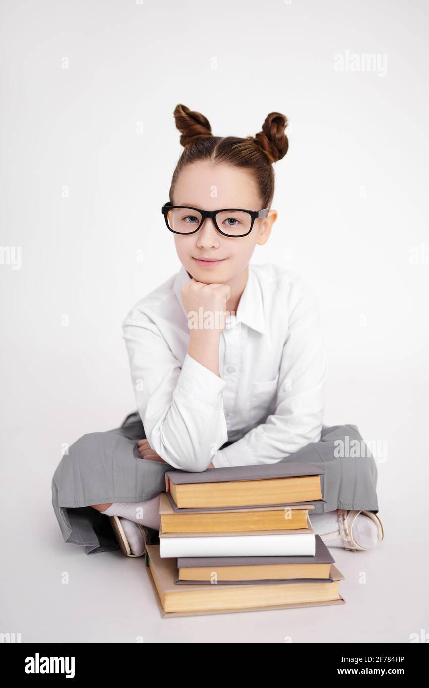 preteen school uniform portrait of cute preteen girl in school uniform and eyeglasses sitting with  heap of books over white background Stock Photo - Alamy