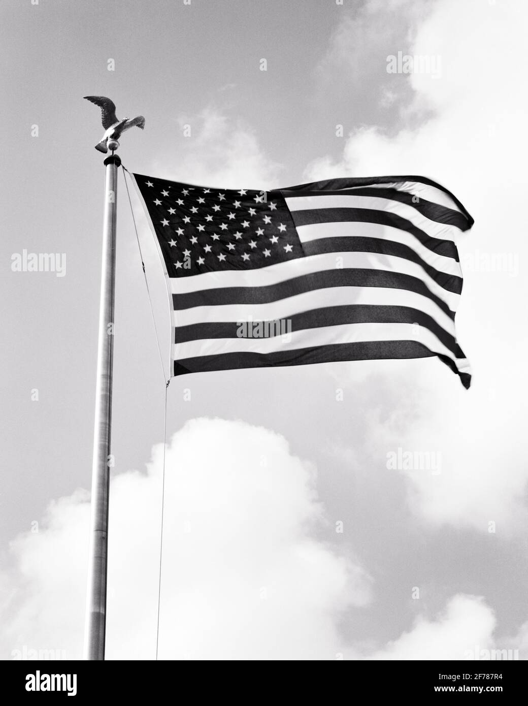 1960s 50 STAR AMERICAN FLAG ON FLAGPOLE WITH EAGLE MOTIF ON TOP - h7564 HAR001 HARS REPRESENTATION Stock Photo