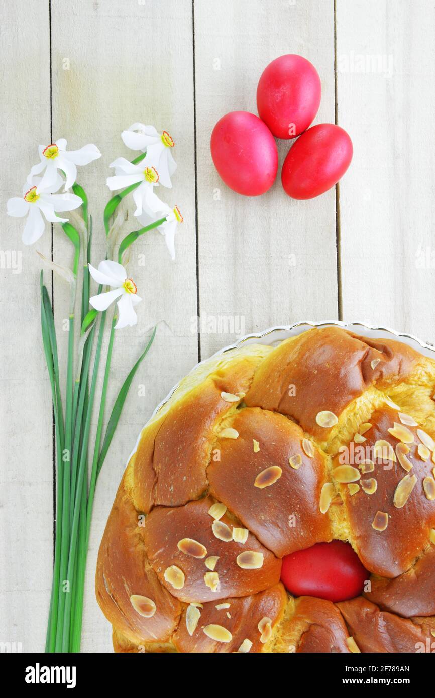 Daffodil flowers,Easter eggs and Easter bread on wooden table Stock Photo