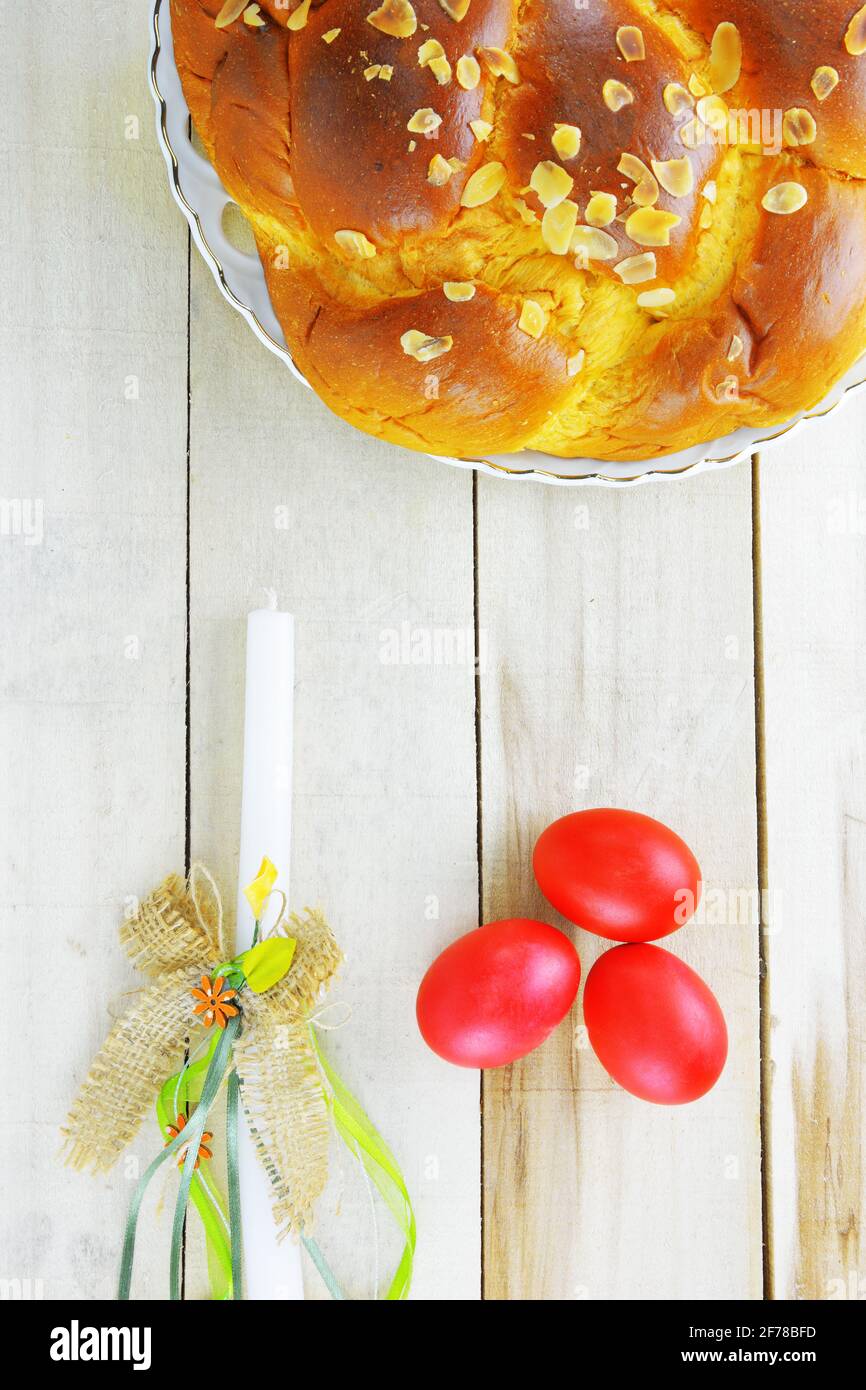 Easter candle,Easter red eggs and Easter bread on wooden table Stock Photo