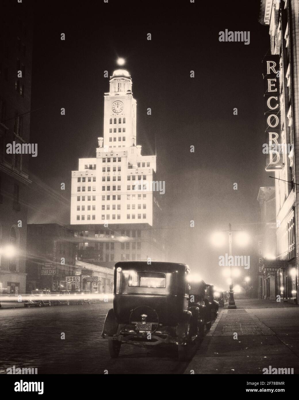 1930s NORTH BROAD STREET NIGHT LIGHTED ELVERSON BUILDING HOME OF THE INQUIRER & NEON FOR THE RECORD BUILDING PHILADELPHIA PA USA - q74160 CPC001 HARS AUTOS EXTERIOR LOW ANGLE PA BROAD REAL ESTATE COMMONWEALTH BROAD STREET STRUCTURES AUTOMOBILES CITIES FOURTH ESTATE KEYSTONE STATE VEHICLES EDIFICE STREET LAMPS NIGHTTIME BLACK AND WHITE CITY OF BROTHERLY LOVE LAMPPOSTS LIGHTED OLD FASHIONED Stock Photo