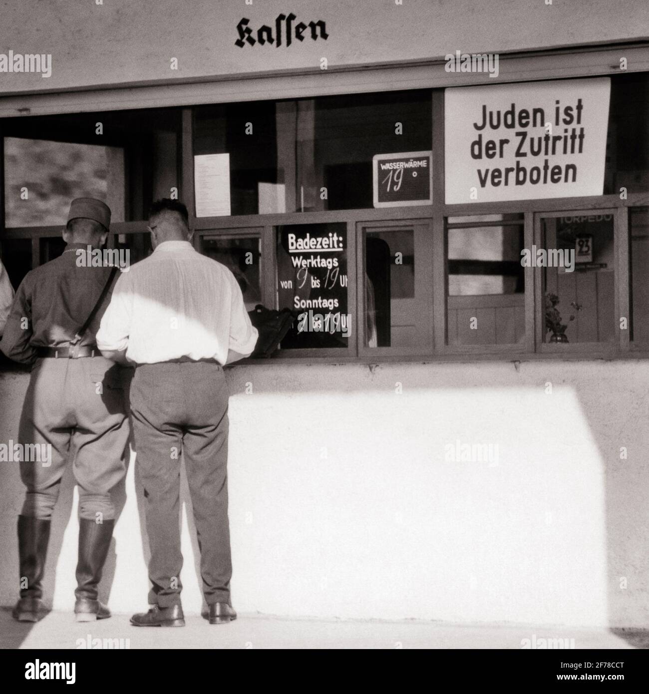1930s 1940s TWO MEN ONE IN NAZI HAT SHIRT JACK BOOTS AT COFFEE SHOP SIGN IN WINDOW SAYS ADMISSION OF JEWS IS FORBIDDEN GERMANY - s5962 HAR001 HARS FULL-LENGTH GERMANY PERSONS MALES RISK B&W SADNESS IS DISASTER RELIGIOUS EXTERIOR FORBIDDEN ARE AT IN OF ADMISSION POLITICS CONCEPTUAL NAZI FASCIST PERSECUTION ADMITTANCE FASCISM SAYS ANTI-SEMITISM BLACK AND WHITE CAUCASIAN ETHNICITY HAR001 OLD FASHIONED RESTRICTED Stock Photo