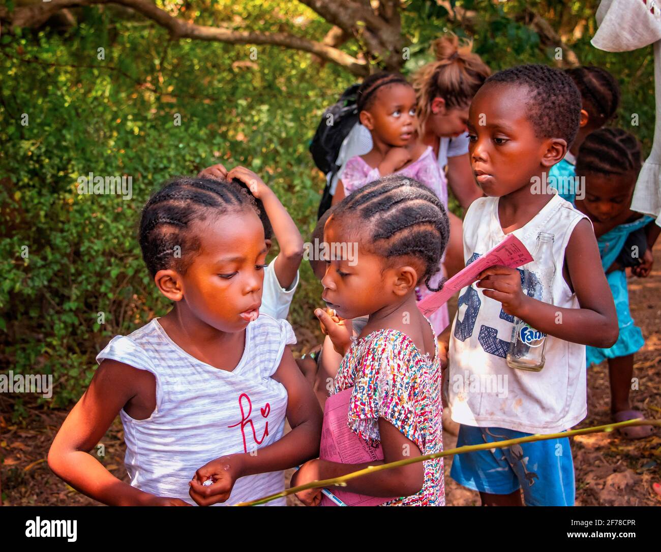 Wasini island, Kenya, AFRICA - February 26, 2020: Little local children begging for sweets from tourists on Wasini island, Kenya. This is happening in Stock Photo
