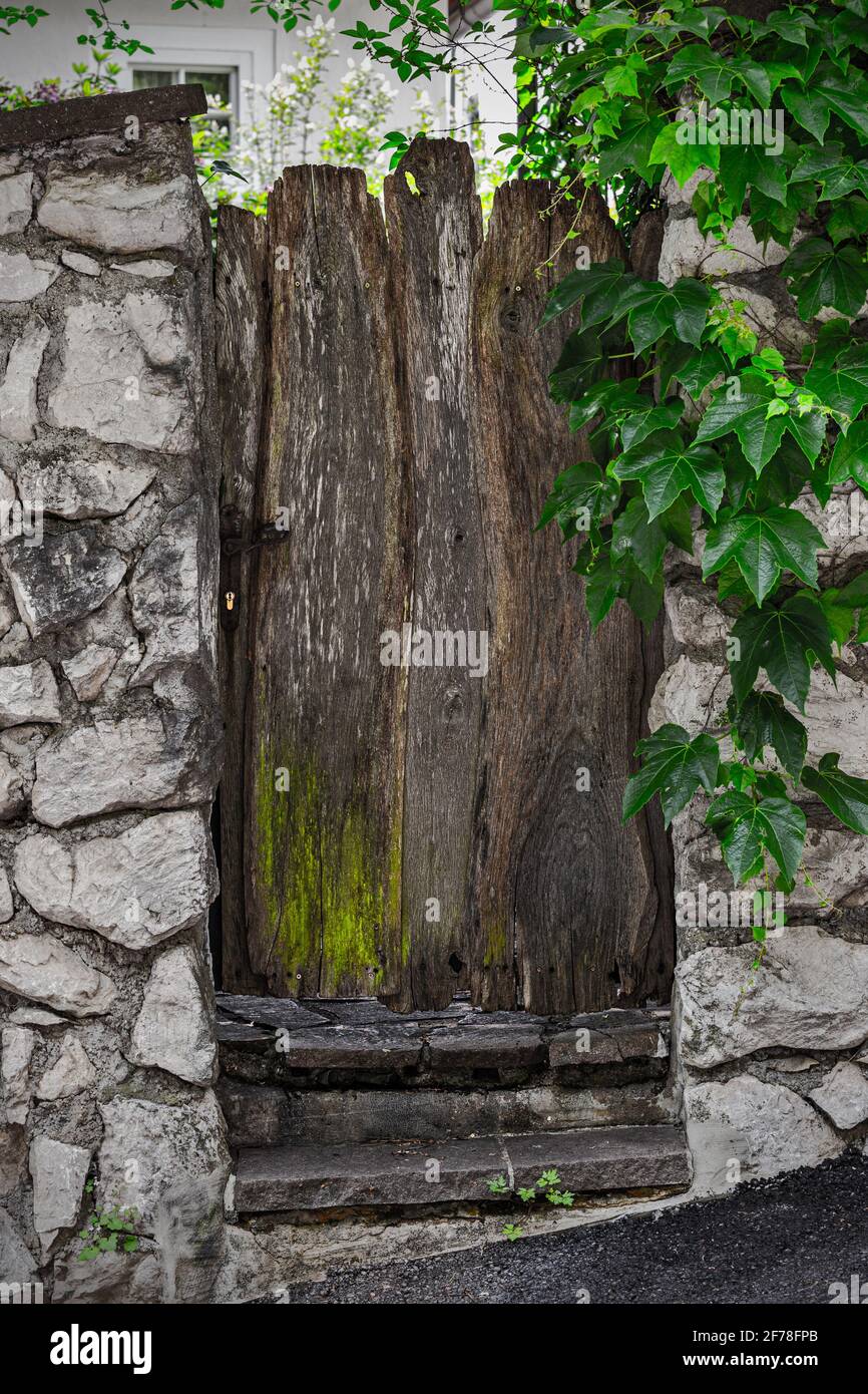 Old raw wooden door between stone walls Stock Photo Alamy