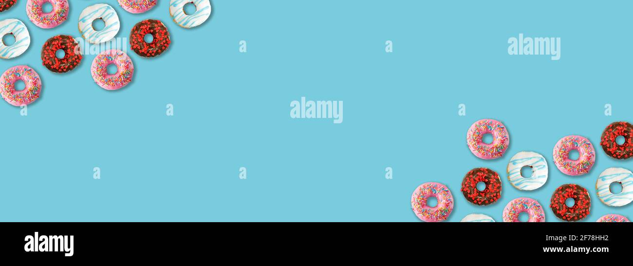 Delicious colorful donuts on blue background, flat lay. Space for text Stock Photo