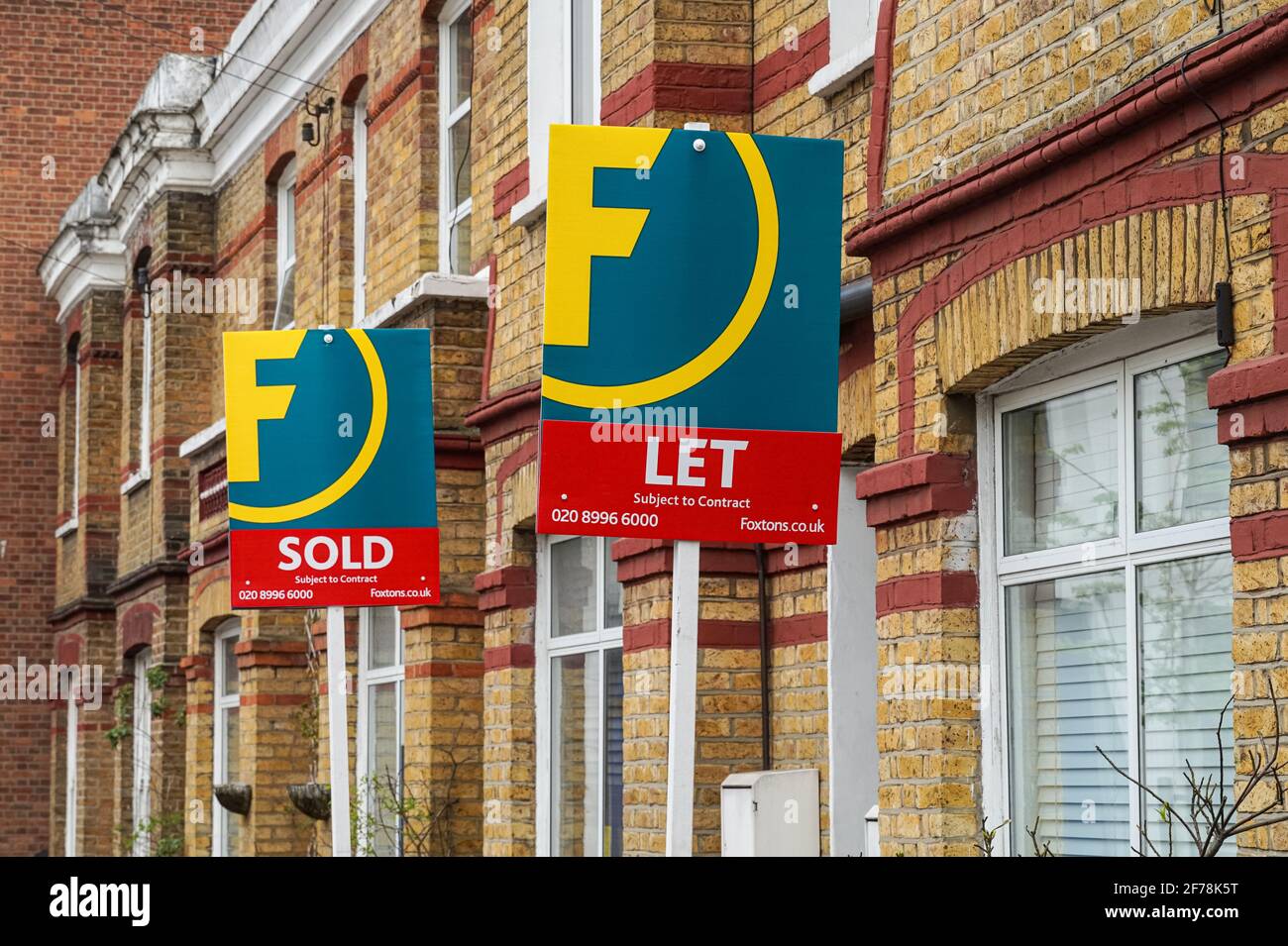 Foxtons real estate sold and to let signs outside brick terraced houses in west London England United Kingdom UK Stock Photo