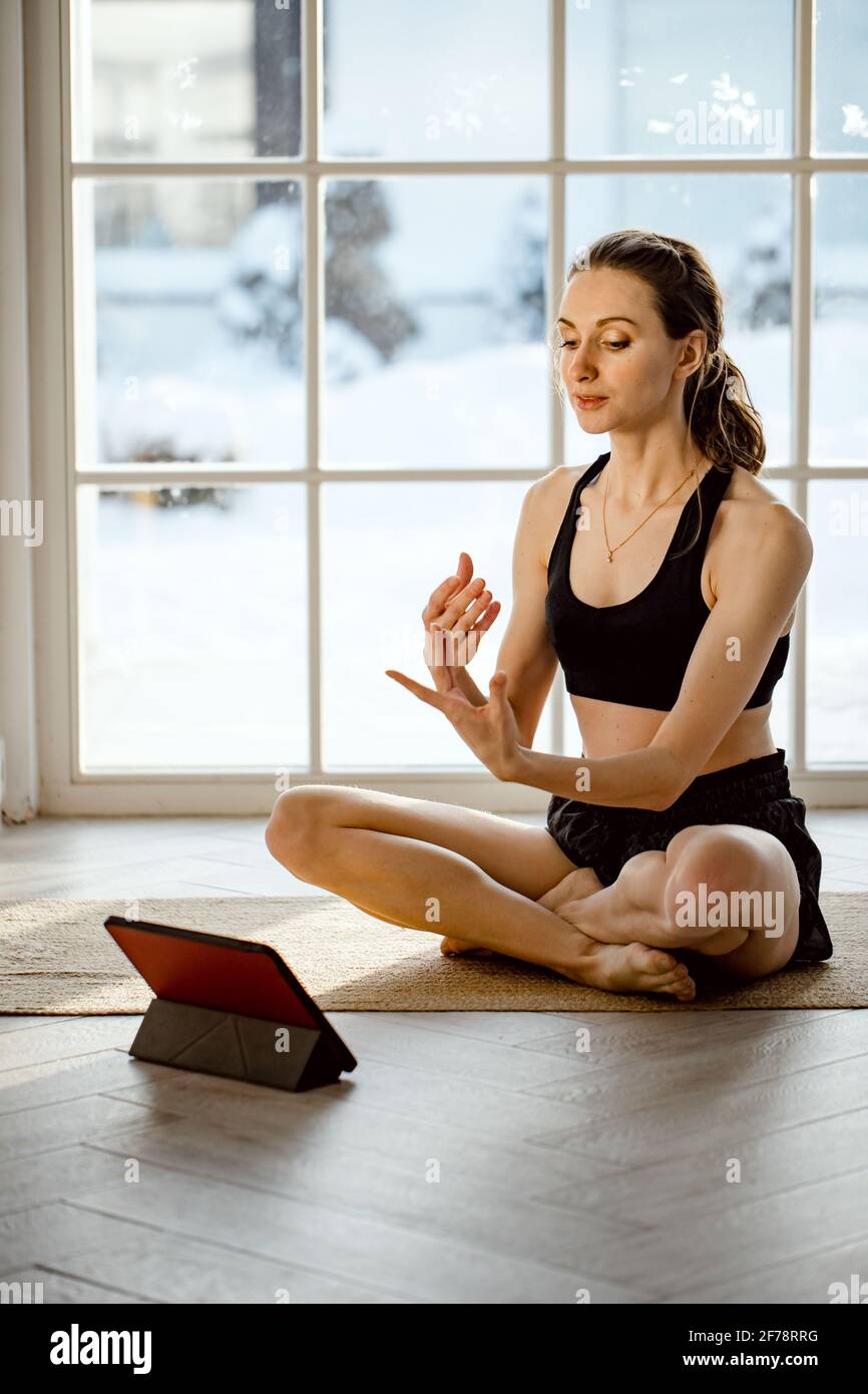 Yoga teacher conducting virtual yoga class at home on a video conference.  Beautiful fit woman practicing online yoga with tablet. Home fitness and  wor Stock Photo - Alamy