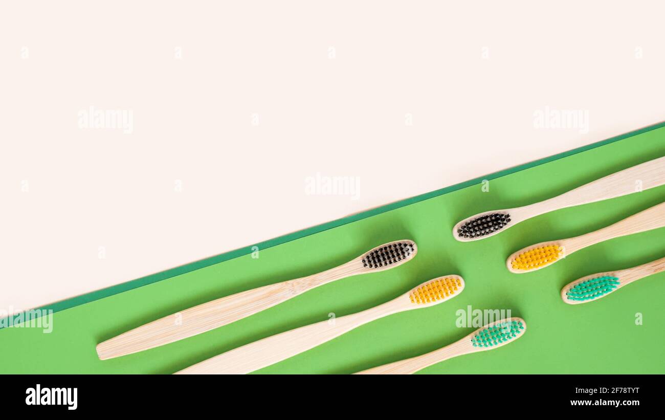 Eco-friendly bamboo toothbrushes on double pastel beige and green background. Colorful natural wooden tooth brushes as plastic free dental care Stock Photo
