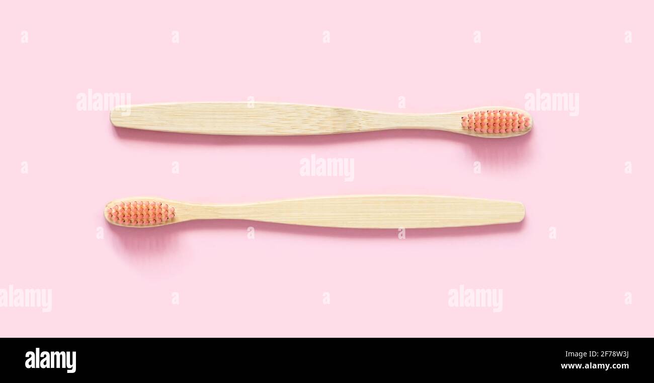 Eco-friendly bamboo toothbrush on pastel pink background. Two natural ...
