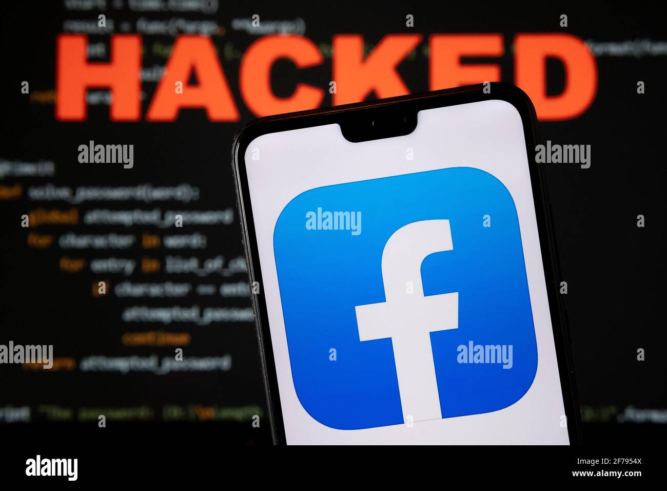 Facebook app logo seen on the smartphone and blurred HACKED word with a brute force script on the blurred background. Concept for facebook data breach Stock Photo
